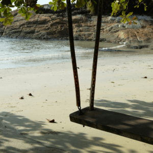 a wooden swing on a beach